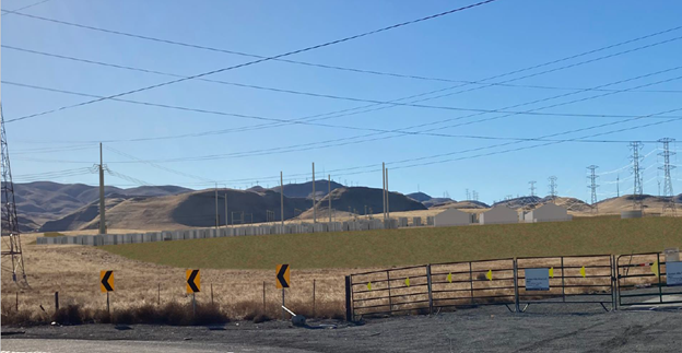 View from the road of a hillside with battery storage containers for the Potentia-Viridi Battery Storage System