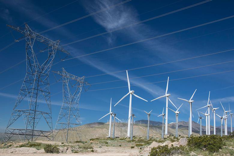 Windmills and high-power transmission lines along hillside