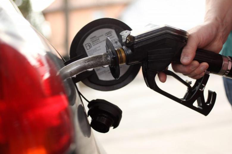 Gasoline pump nozzle being inserted into vehicle