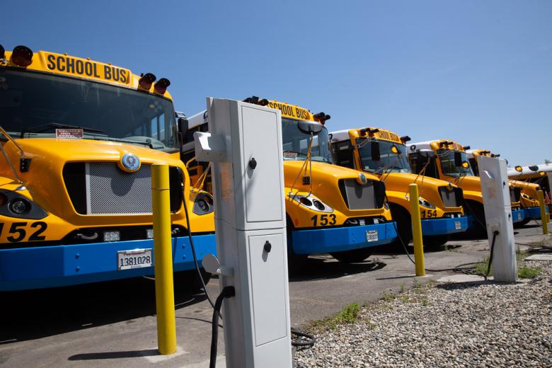 Image of a school bus fleet at a charging station.