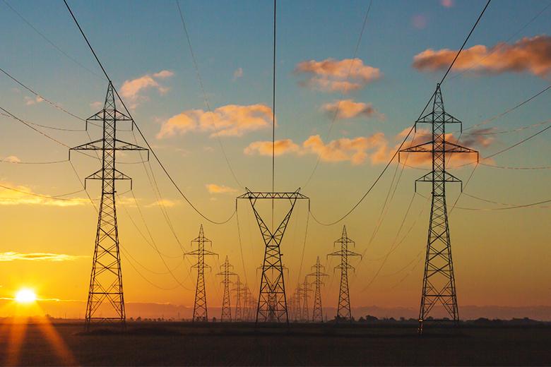 Image of sunset behind power lines.