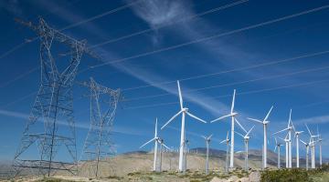 Windmills and high-power transmission lines along hillside